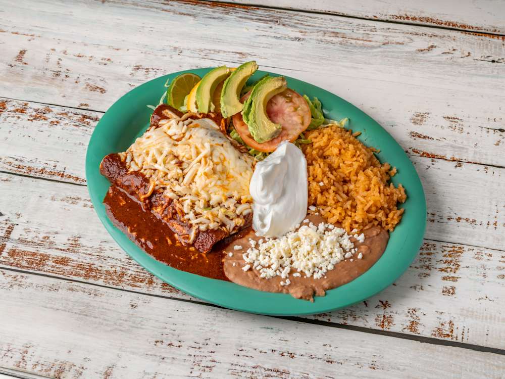Enchiladas smothered in homemade salsa and melted cheese, with rice and beans